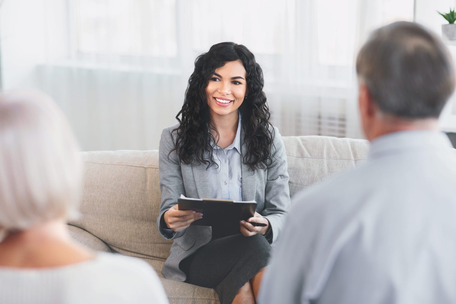 Senior couple talking to financial advisor at her office prestamos personales